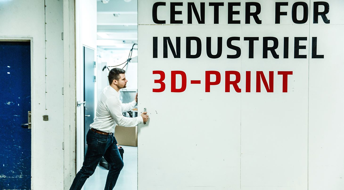 Mand skubber port op ind til center for industriel 3D-print